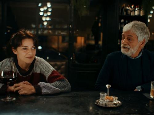 una ragazza e un signore anziano al bancone di un bar